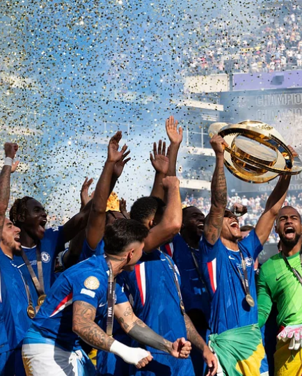 France's national soccer team celebrates a championship victory, with a player hoisting the trophy as confetti rains down over a packed stadium crowd.