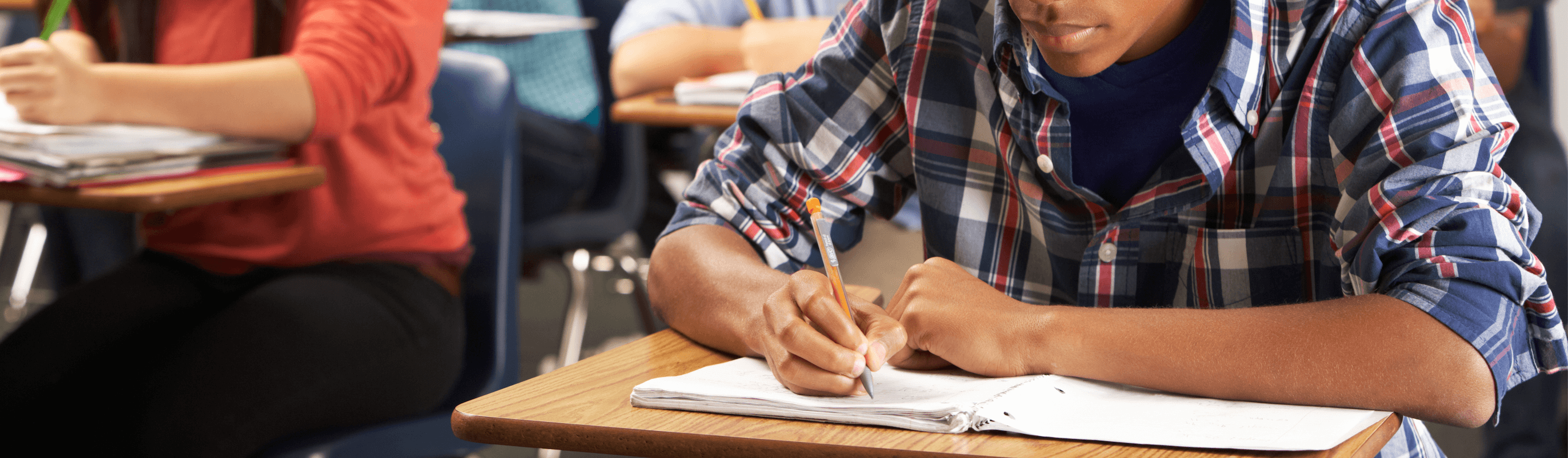 Student hand holding a pencil prepares to take pre-assessment test.
