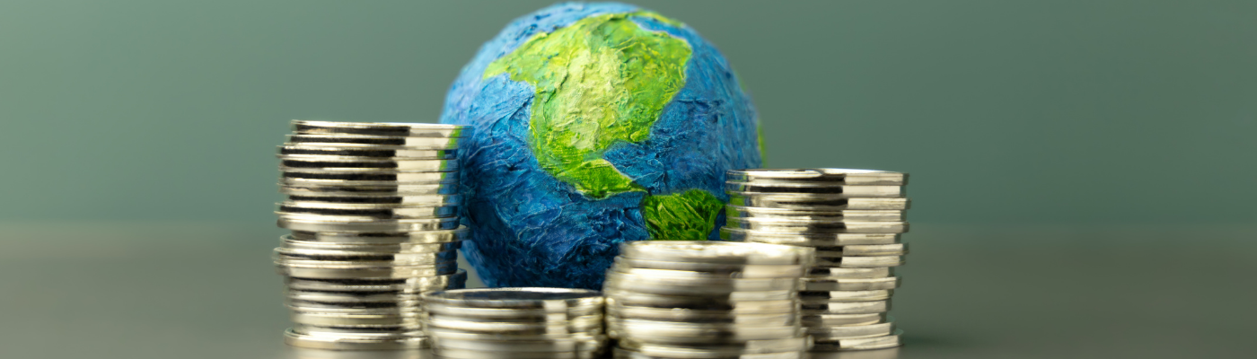 Stacks of silver coins arranged around a hand-painted globe, representing the analysis of macroeconomic data and its real-world implications explored in this lesson.