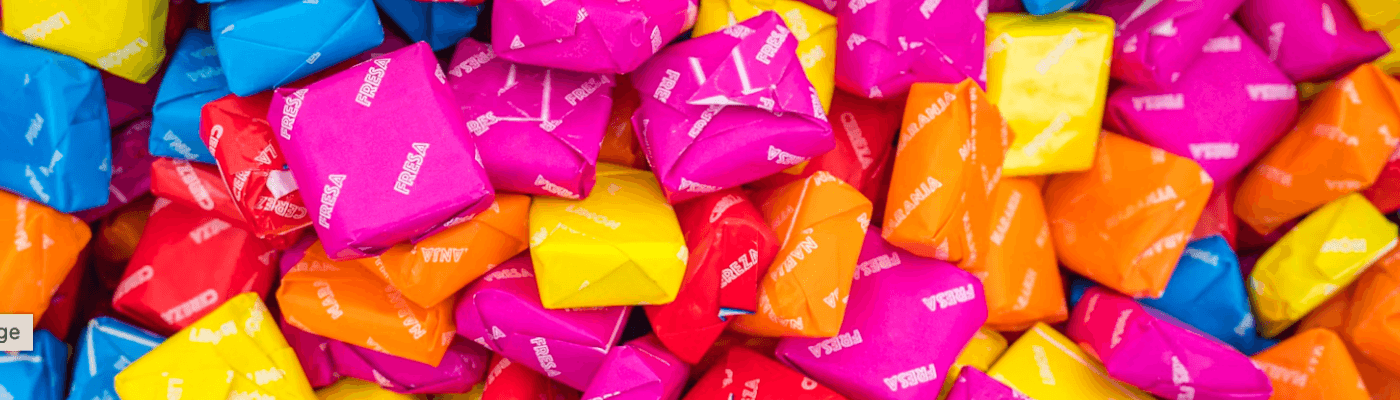 A colorful pile of wrapped Starburst candies in pink, orange, yellow, red, and blue, representing the trade simulation where students exchange candies to explore voluntary exchange and utility.