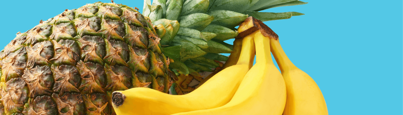 A pineapple and a bunch of bananas against a bright teal background, representing the Thailand-Indonesia comparative advantage model used to explore specialization and gains from trade.