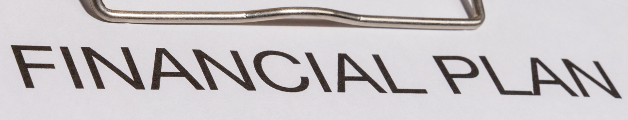 "Financial Plan" in large typeface across the top of a clipboard.