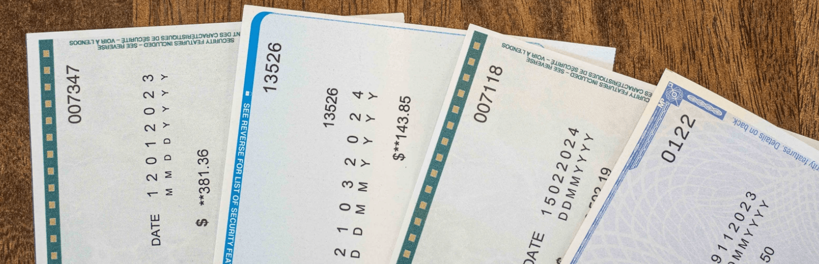 Four pay checks overlapping one another.