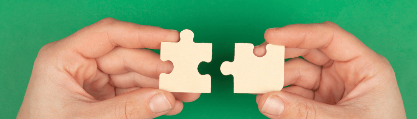 A set of hands hold two complementary puzzles pieces.